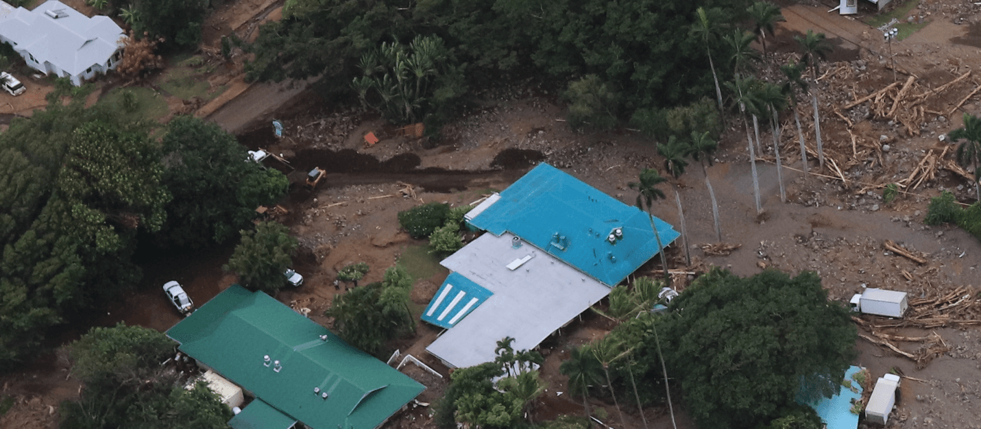 Homes and vehicles buried by mud, boulders and woody debris after a landslide