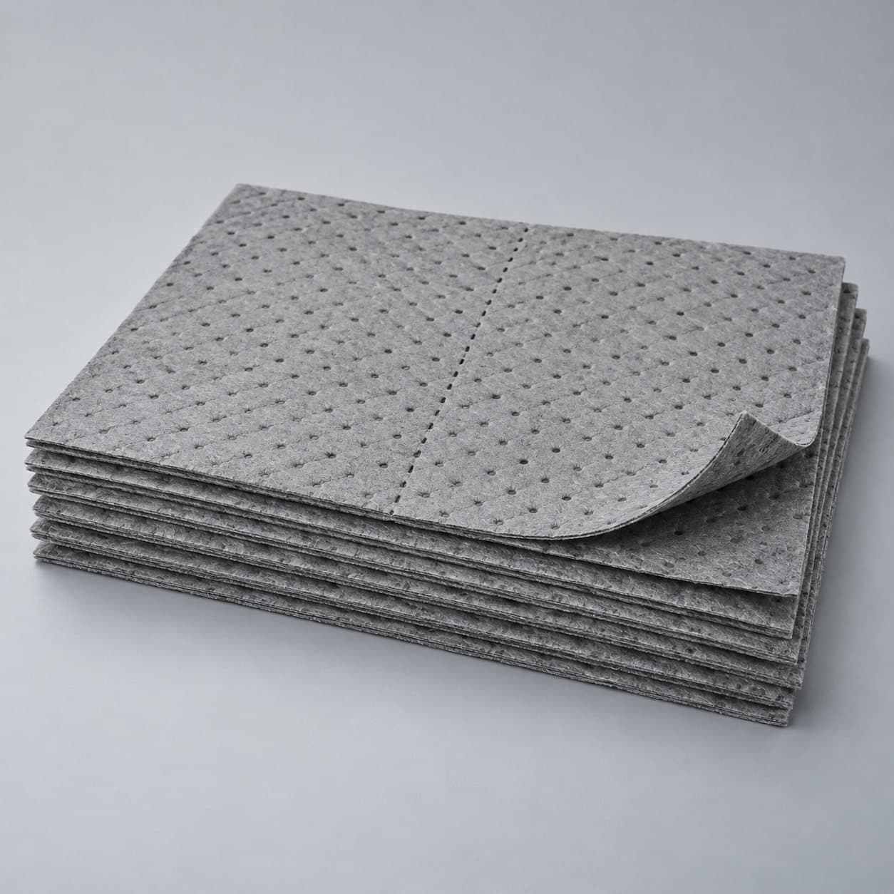 Perforated universal absorbent mats for general industrial spills